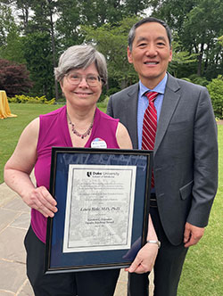 Laura Hale, MD, PhD, with her award and Jiaoti Huang, MD, PhD,