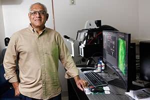 Soman Abraham, BS, MS, PhD, standing at desk