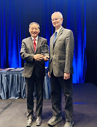Dr. Jiaoti Huang (left) presents Chair’s Excellence Award to, Dr. Thomas J. Cummings (right)