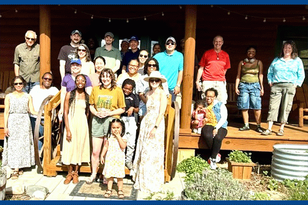 PhD Graduate Students, Faculty, and Staff with their family on Dr. Staat's porch