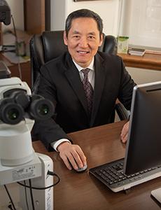 Dr Jiaoti Huang sitting at desk