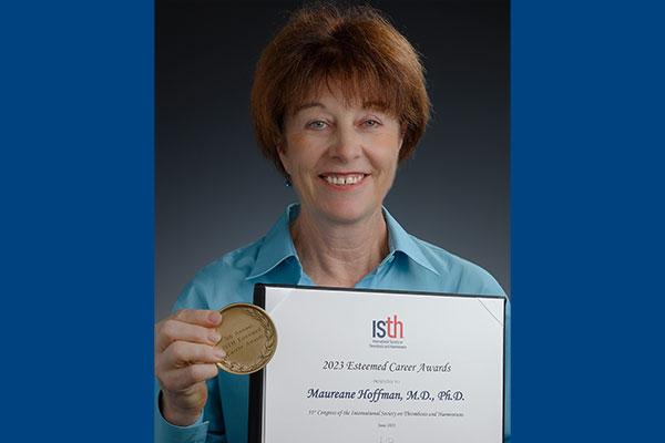 Maureane Hoffman, MD, PhD, with Esteemed Career Award certificate