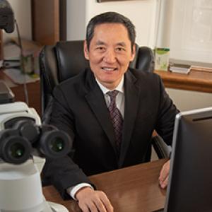 Dr Jiaoti Huang sitting at desk