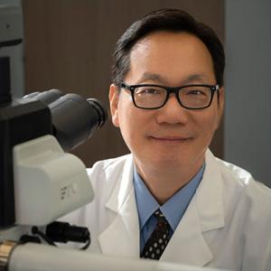 Ken H. Young, MD, PhD, at microscope