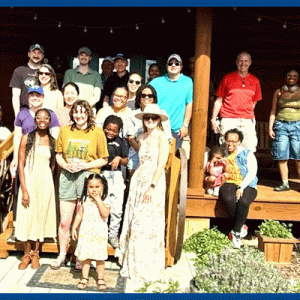 PhD Graduate Students, Faculty, and Staff with their family on Dr. Staat's porch